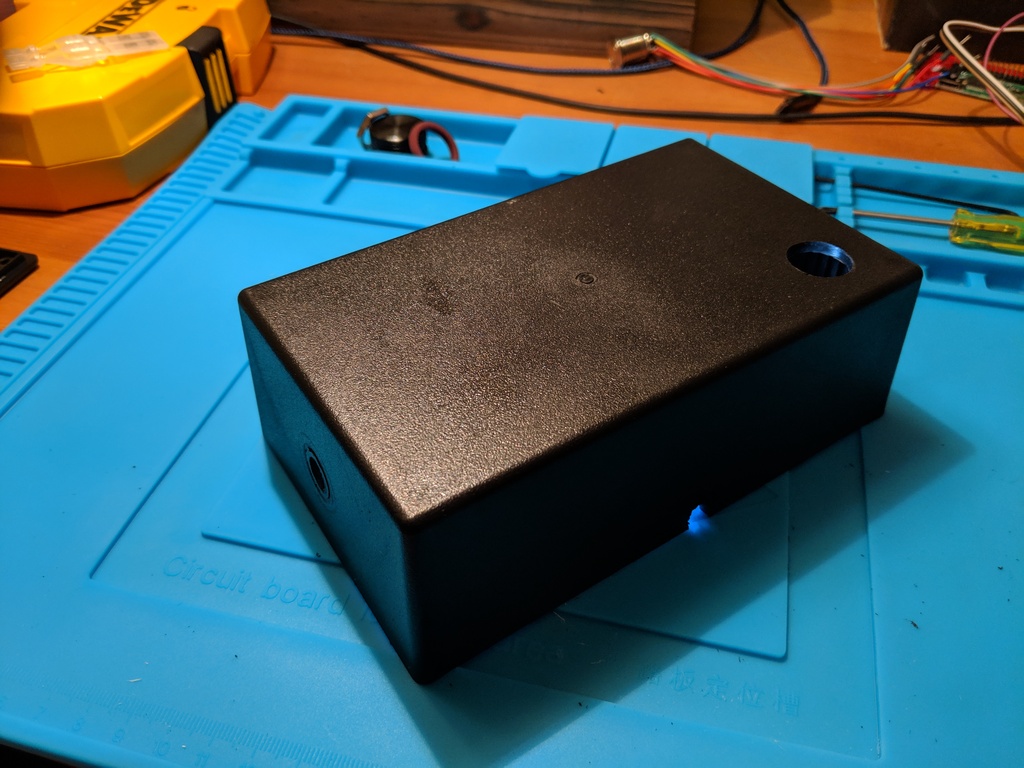 Enclosure with holes for power button, encoder, and power cord